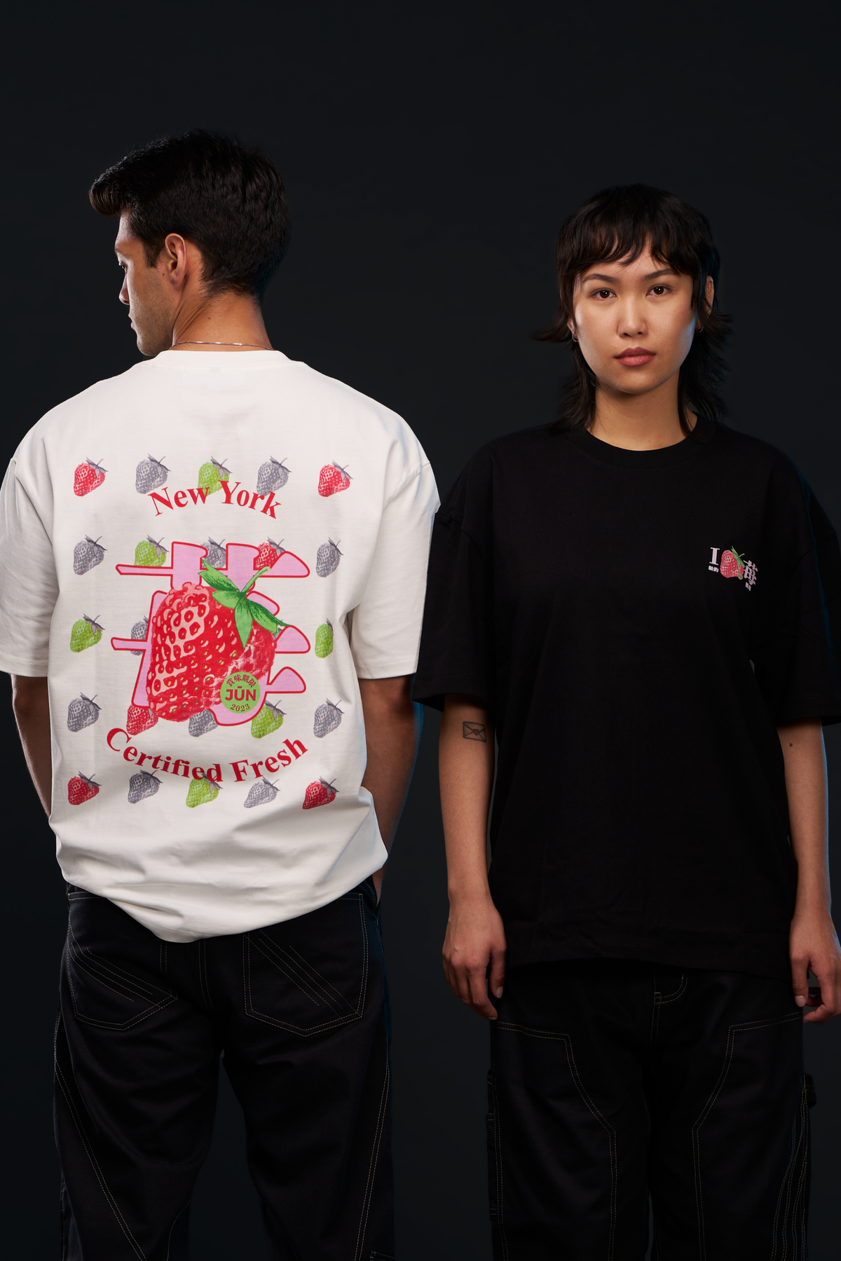 ICHIGO. TEE in white and black — worn, two models side by side, white back strawberry graphic and black chest logo
