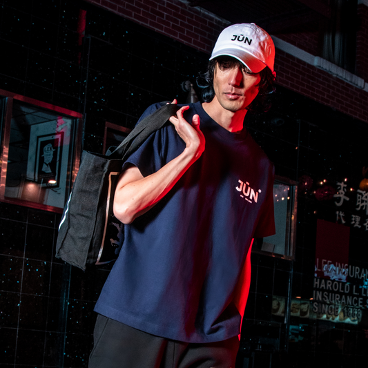 INSIGNIA. TEE in navy — worn, JŪN chest logo, night street scene